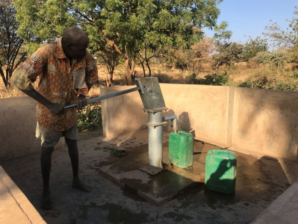 Ein Burkinabe an einer Wasserpumpe